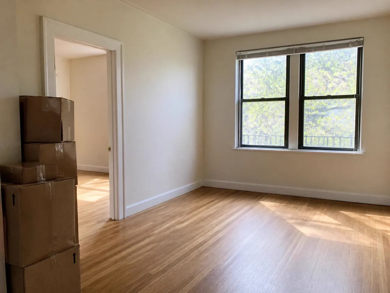 Empty apartment on move-in day with moving boxes stacked by the door